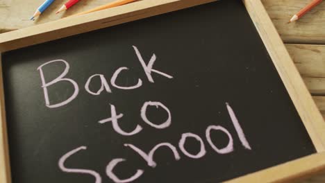 video of tablet with back to school and school items on wooden background