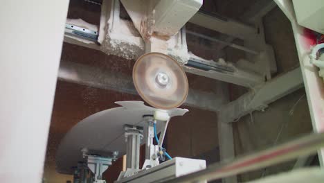 Surfboard-is-sanded-and-shaped-with-automatic-machine-while-dust-particles-float-around