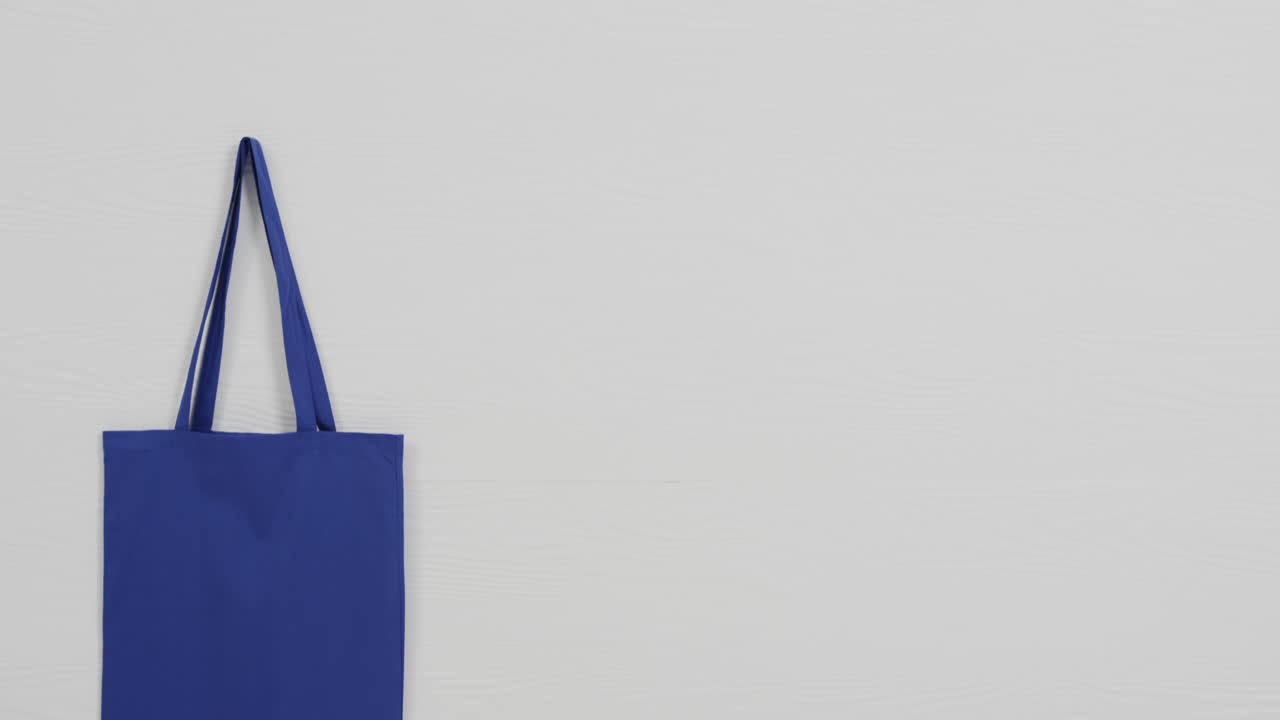 ⁇  바탕에 있는 파란색 가방의 클로즈업, 복사 공간, 슬로우 모션