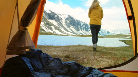 woman camping in the mountains by a lake