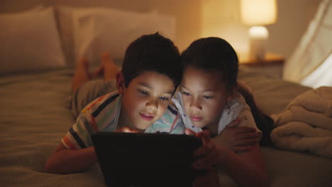 siblings enjoying a nighttime digital activity