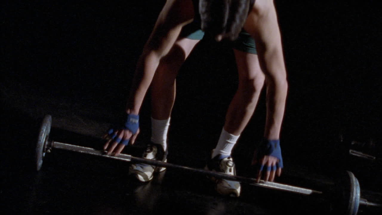 한 청년이 역기를 머리 위로 들다