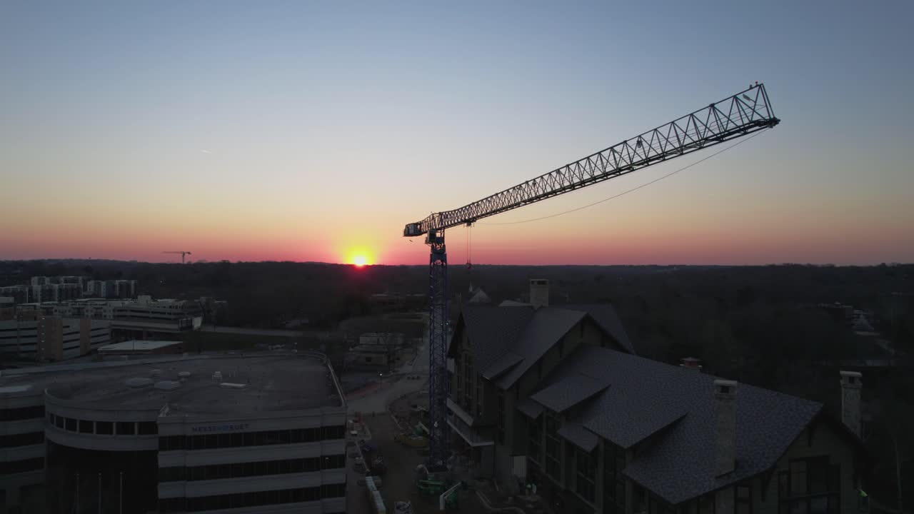 Drone footage of idle crane at dawn with sun coming over the horizon.