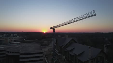 drone footage of idle crane at dawn with sun coming over the horizon.