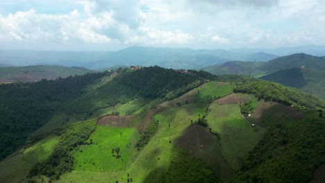 mountain top village amidst remote farmland in northern laos: lush fields, traditional farming, deforestation, and crop burning