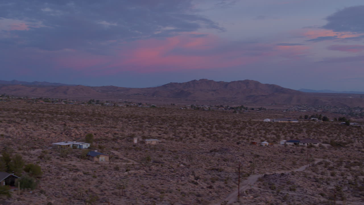 Vista aerea panoramica di un paesaggio desertico con case al tramonto a Joshua Tree, California.