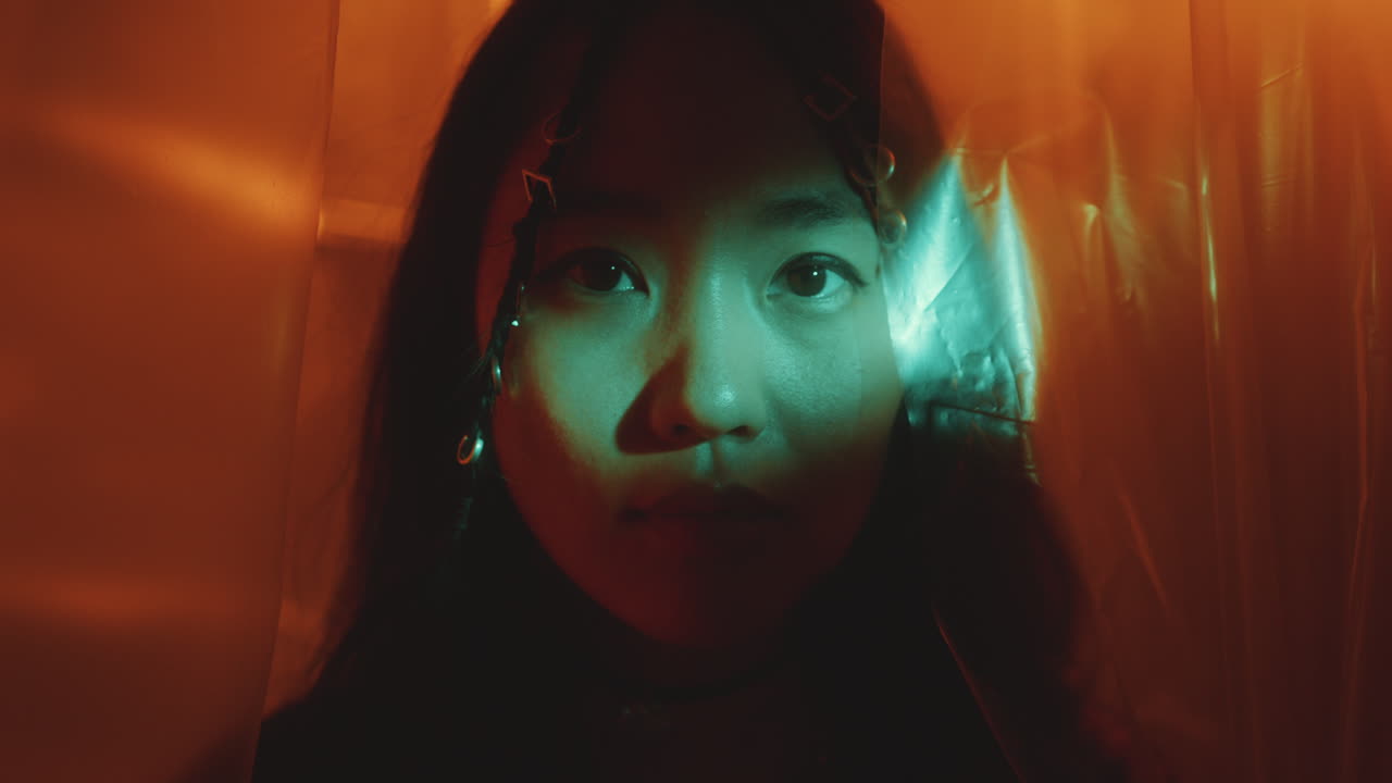 Portrait of Attractive Asian Woman with Light Beam Shining on Face