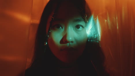 portrait of attractive asian woman with light beam shining on face