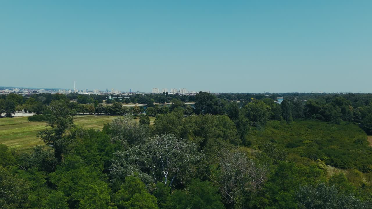 green fields and trees open toward blue lake and city skyline in Zagreb