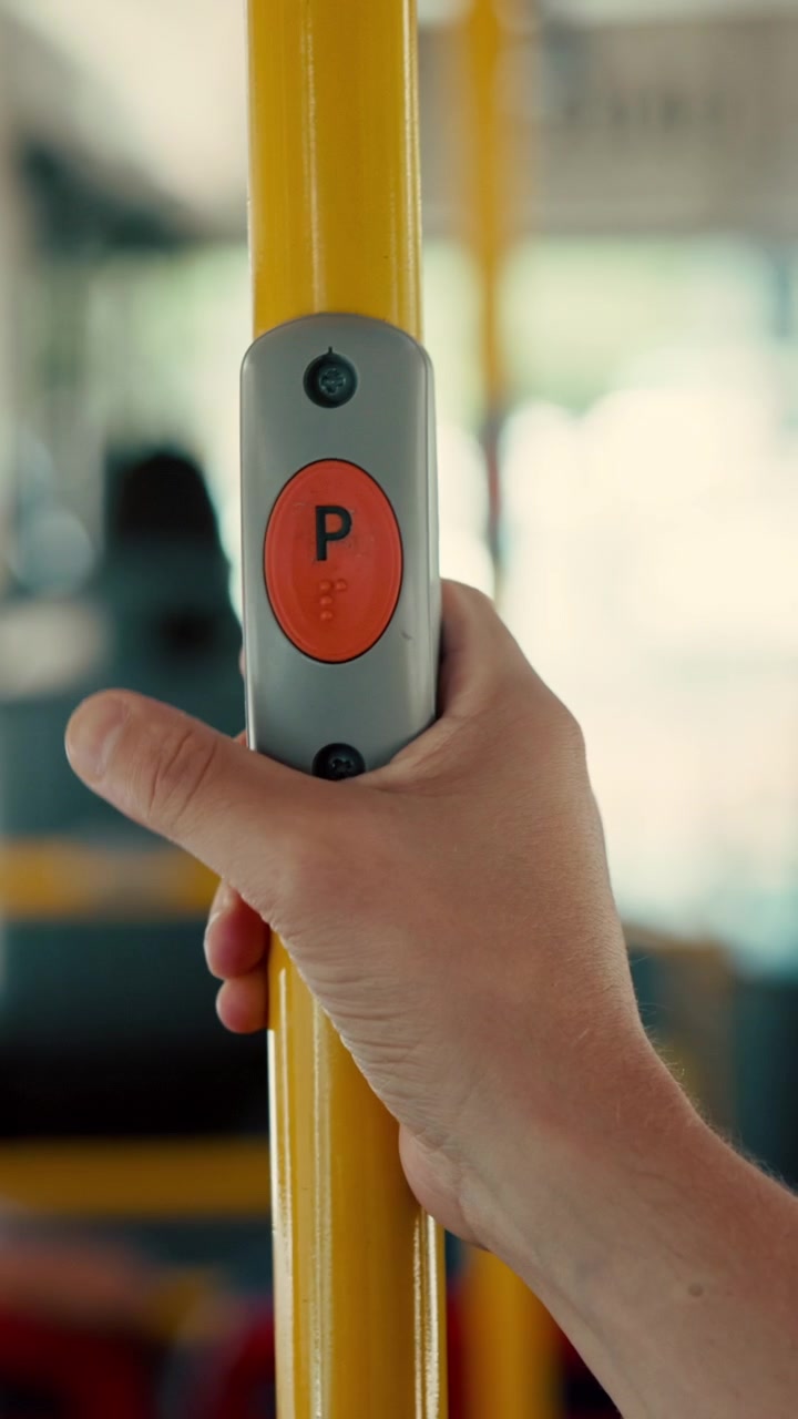Passenger Pressing Stop Button on Public Bus