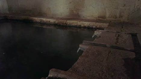 tourists visiting natural spa banos del inca indoor thermal pool, peru