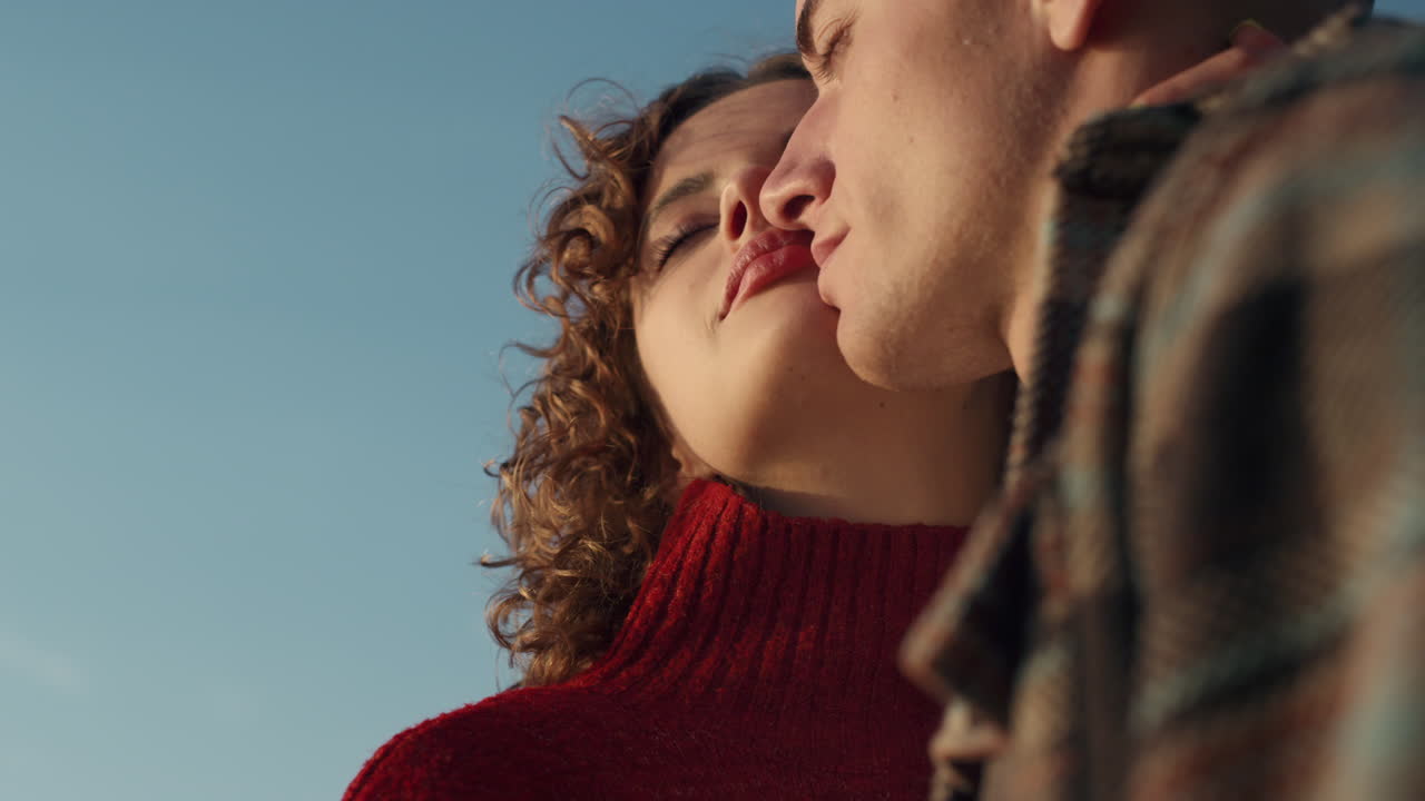 Loving couple posing at camera. Smiling woman and man cuddling together