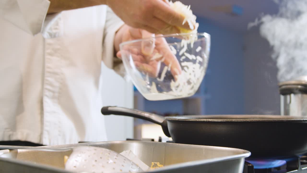 Hands of chef frying chips in steaming pan. Low angle perspective