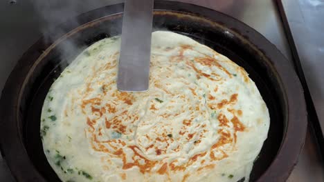 Close-up-slow-motion-shot-of-frying-Taiwanese-pancake-with-eggs