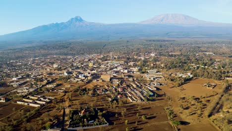 Sonnenaufgang-–-Kenia-Landschaft-Mit-Einem-Dorf,-Kilimandscharo-Und-Amboseli-Nationalpark-–-Verfolgung,-Drohnen-Luftaufnahme