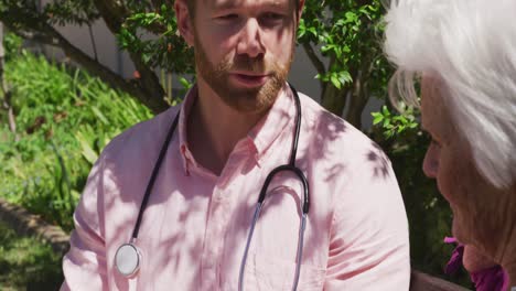 médico con una mujer mayor en el parque de un hogar de ancianos