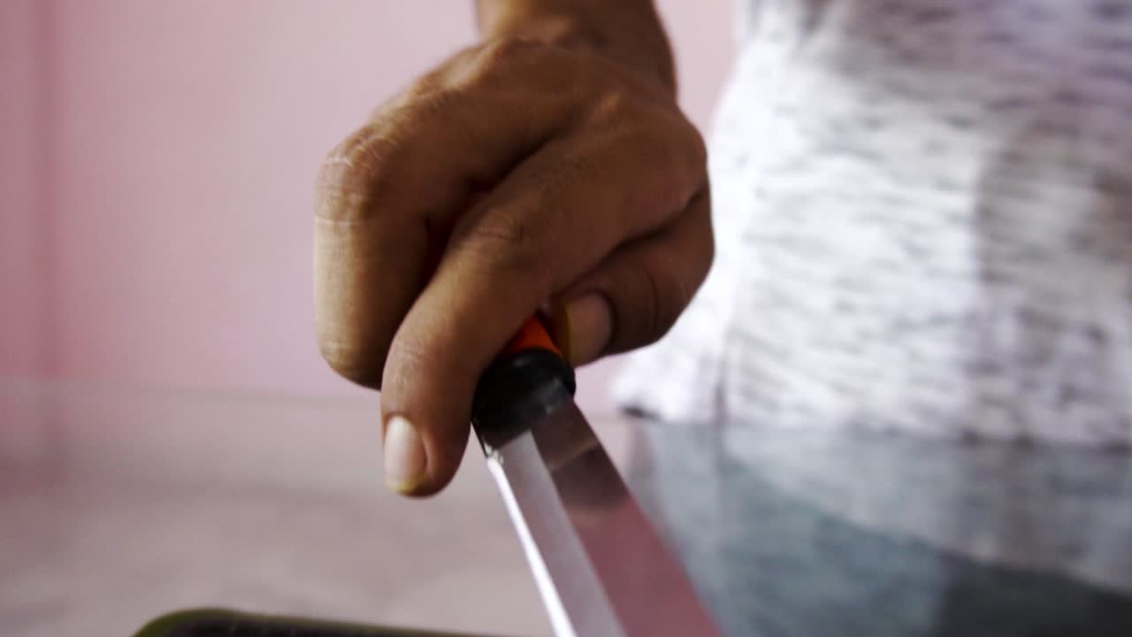 Young man with chopping board and chopping knife making salad