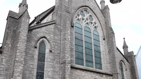 A-shot-of-the-back-of-St-Augustine-Church-in-Galway-City-framed-next-to-a-light-pole,-shot-in-slow-motion-4k