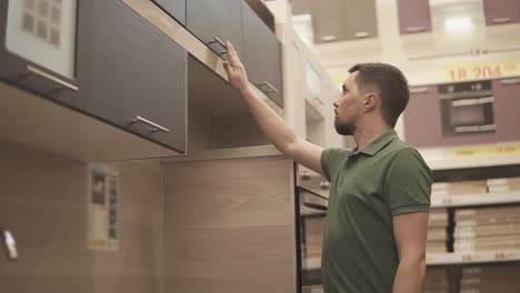 man examining kitchen cabinets in a showroom