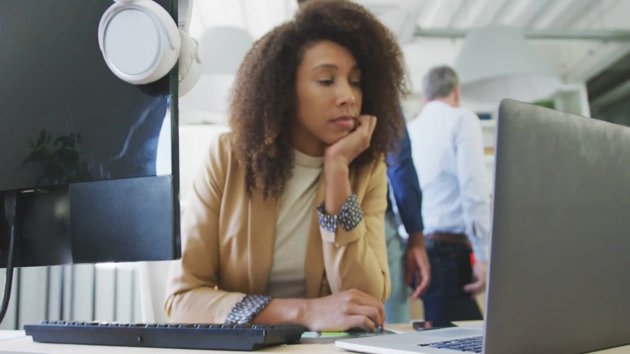 Green glitch obscuring, woman watching laptop and monitoring staff while monitor headset visible