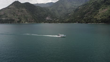 aerial view of speed boat passing by on lake atitlan in guatemala - drone shot