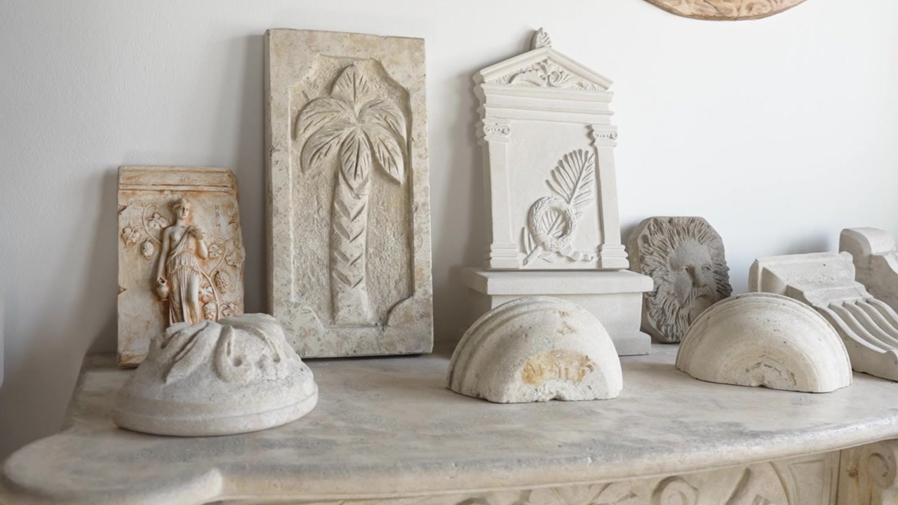 Uma Coleção de Esculturas de Pedra Ornamentadas e Relevos Clássicos é Exibida em um Tampo de Mesa - Close-up