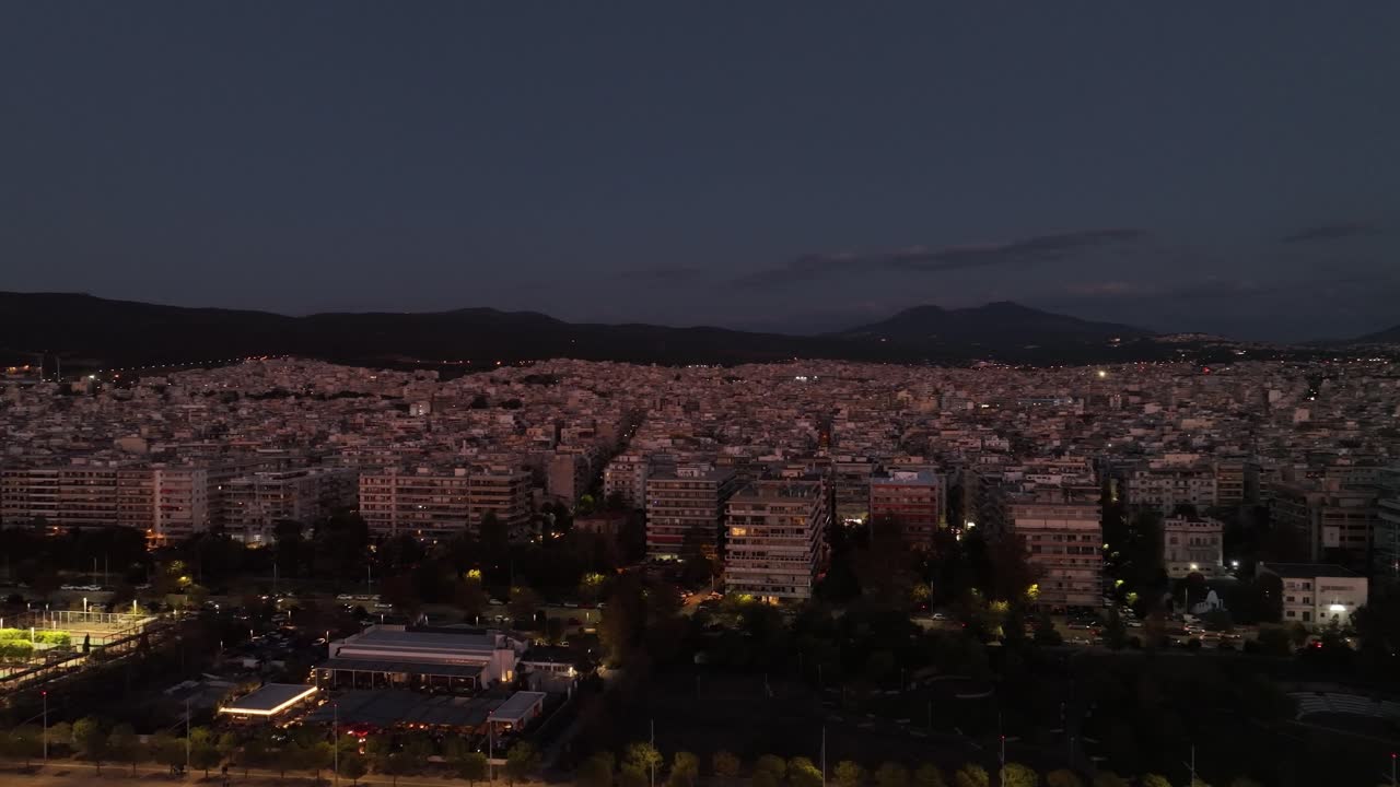 Aerial establishing view of Thermaic gulf, Thessaloniki, Greece, city vibes at night next to Mediterranean sea, summer travel destination landscape, cityscape
