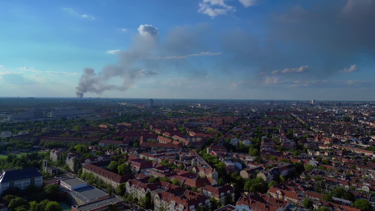 big black smoke rising over Berlin, Germany, on sunny day with blue sky and some clouds. Perfect aerial view flight panorama overview drone