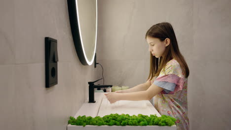 child washing hands in modern bathroom