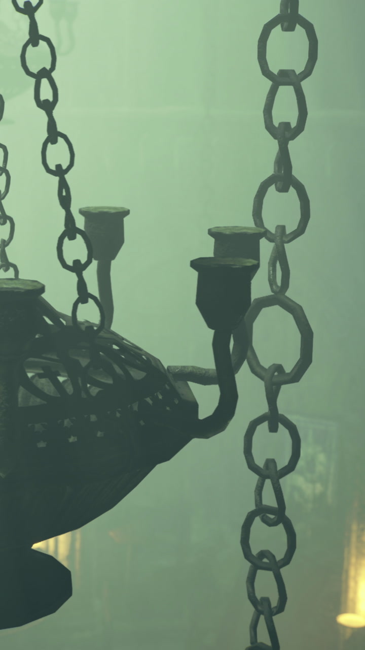Chandelier and chain hanging in a dimly lit space with mist surrounding