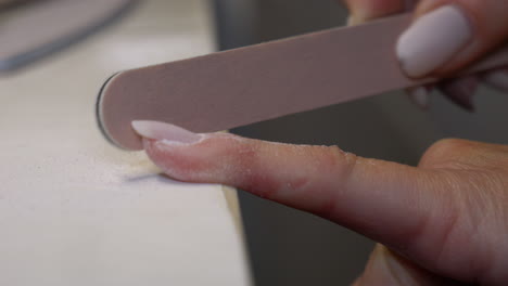 Close-up-shot-of-woman-polishing-finger-nails-with-nail-file-at-home