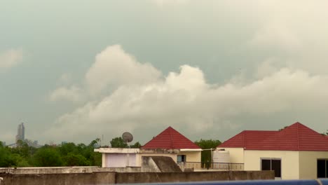 timelapse of blue sky with fast moving white fluffy cloud over a small town