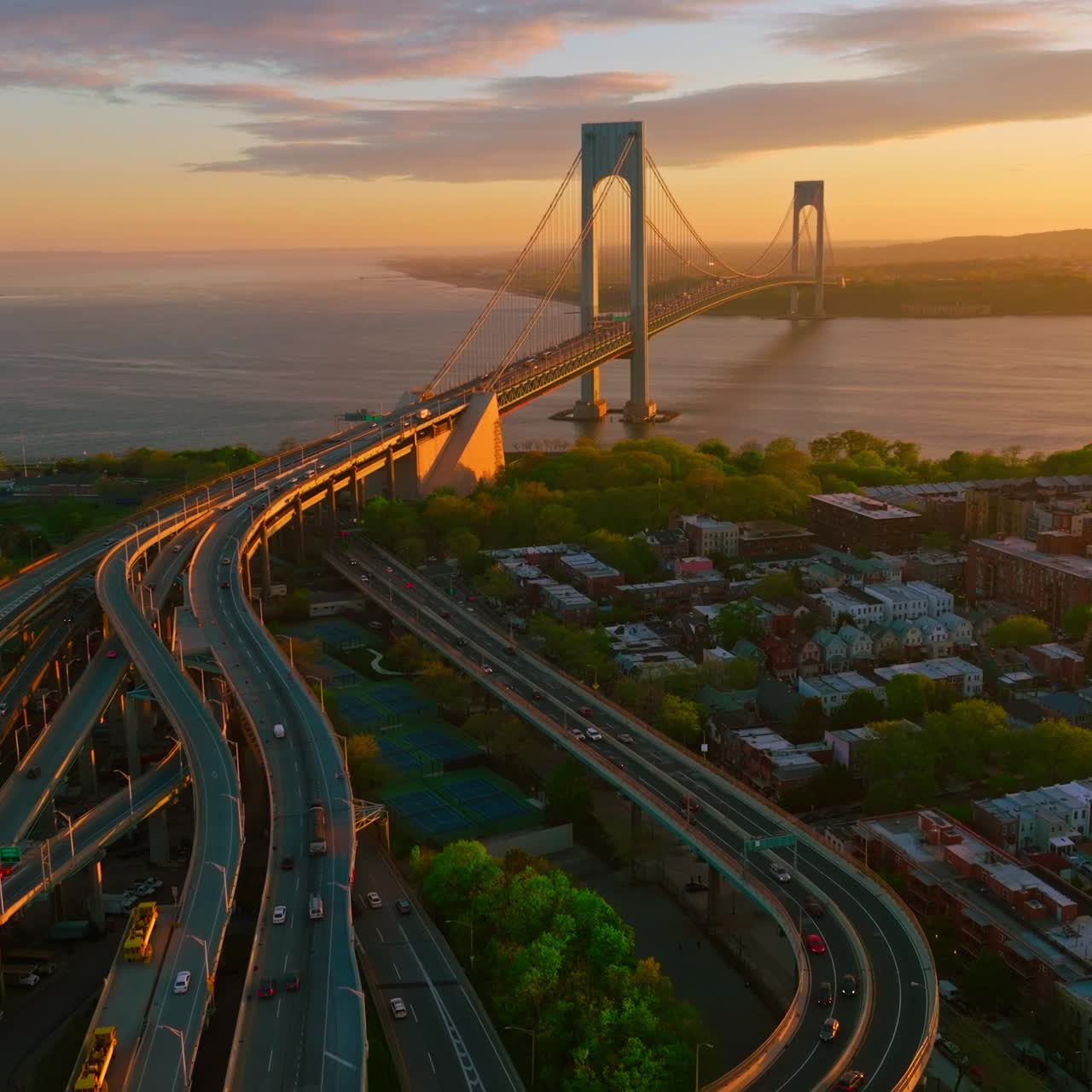 Complicated system of roads leading to Throgs Neck bridge. Impressive bridge structure in the rays of setting sun