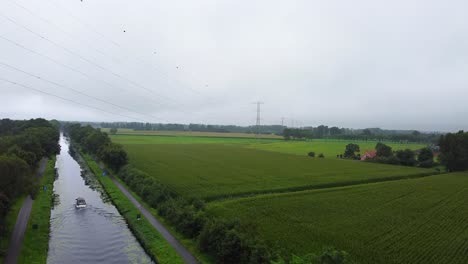 Aerial-view-of-agrilcultural-land-and-boat-crossing-the-canal