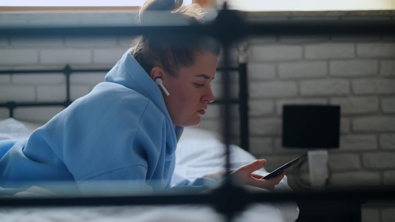 Woman Relaxing in Bed with Phone and Headphones
