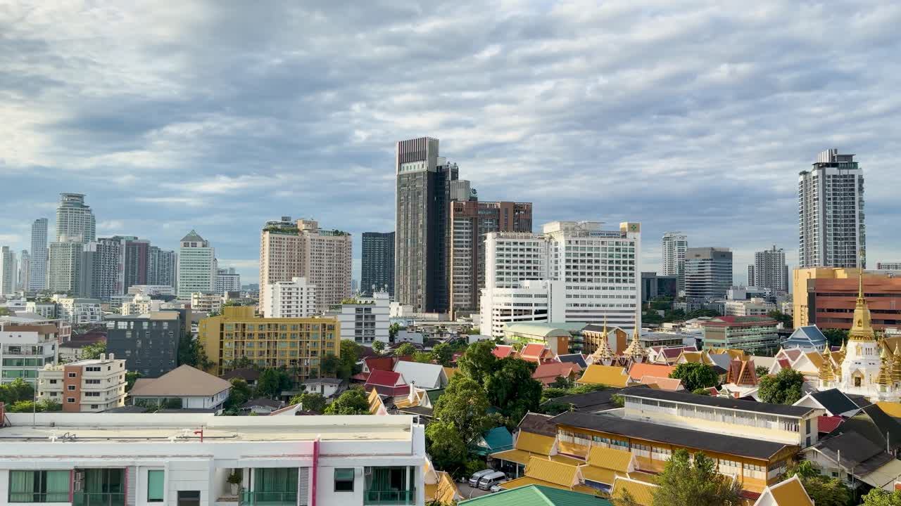 Wide-angle morning cityscape with temples, modern buildings, soft sunlight, and smooth horizontal camera pan