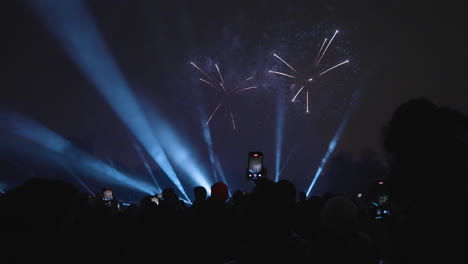 silhouettes against a beautiful fireworks display at night