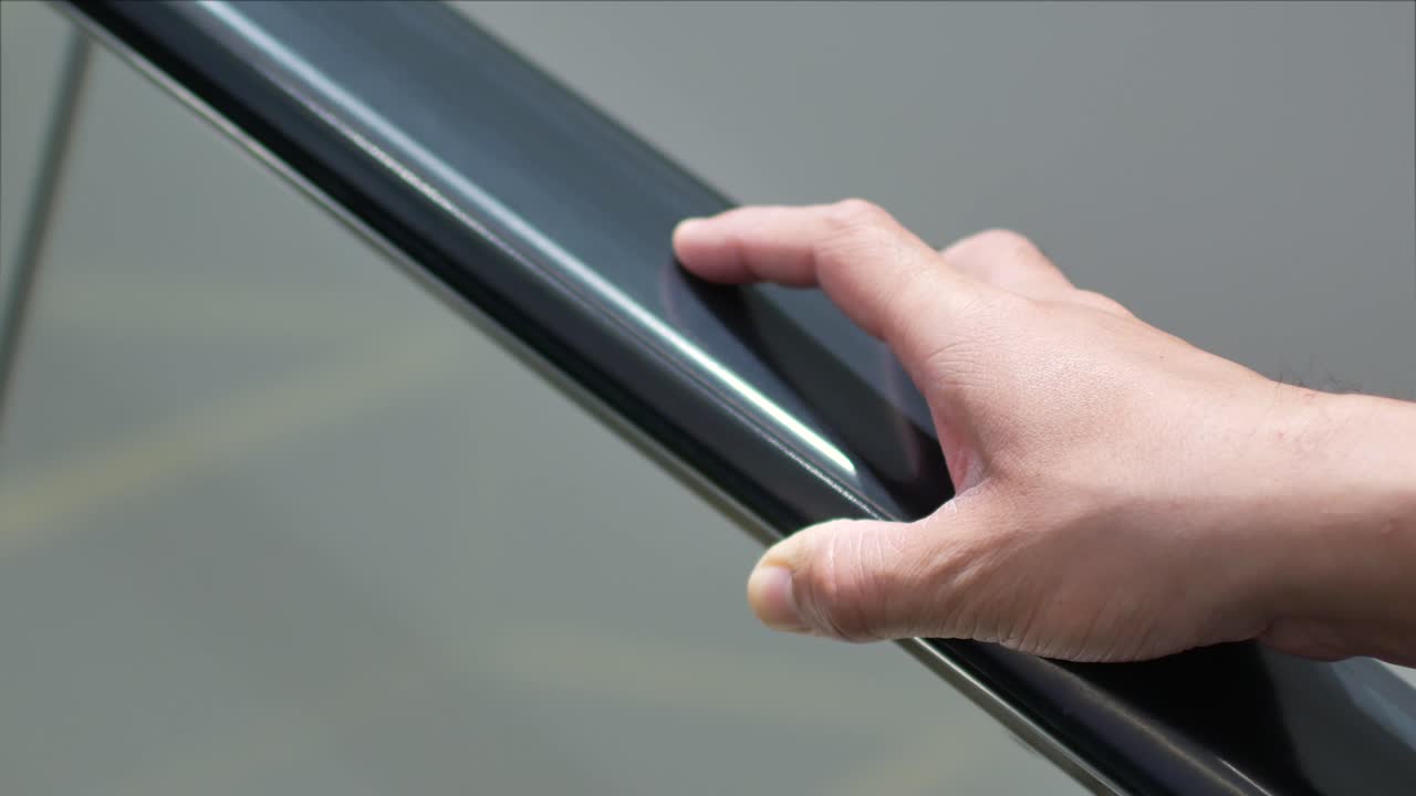 video de 4k en la mano mientras se agarra la computadora de mano en una escalera mecánica en una tienda por departamentos o en el aeropuerto