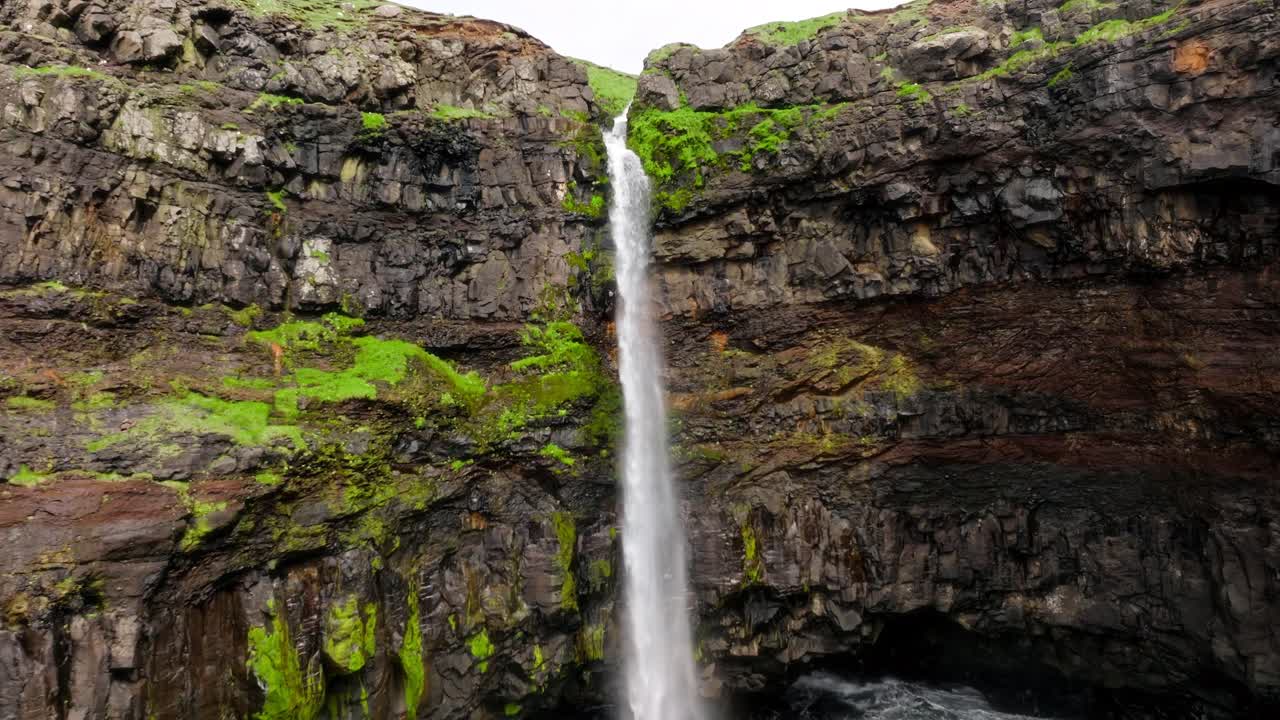una majestuosa cascada cae por los acantilados con exuberante vegetación en gásadalur, faroe