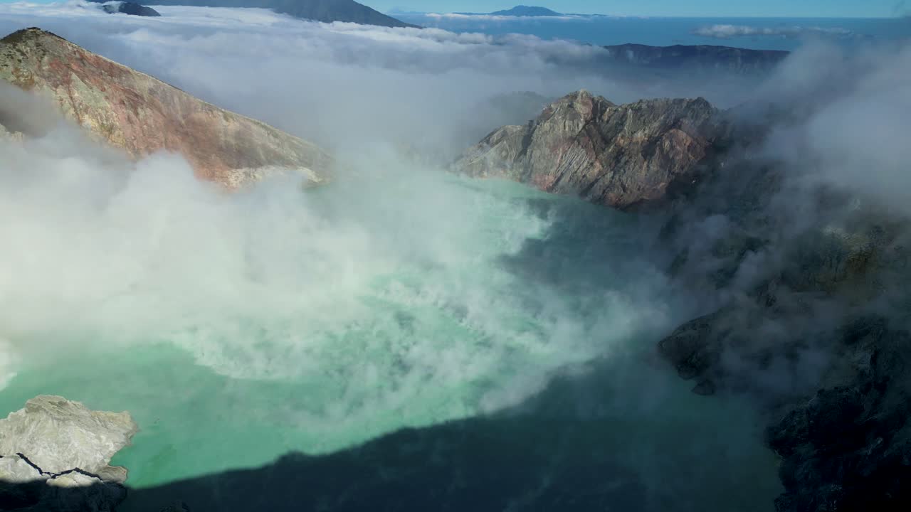 bird eye view of the stunning Ijen Volcano and it's blue lake acid crater in a sunny blue sky day - East Java, Indonesia