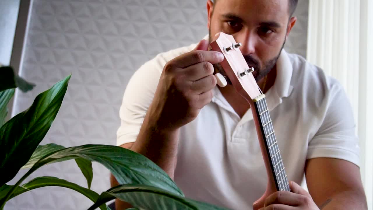 hombre afinando el ukulele
