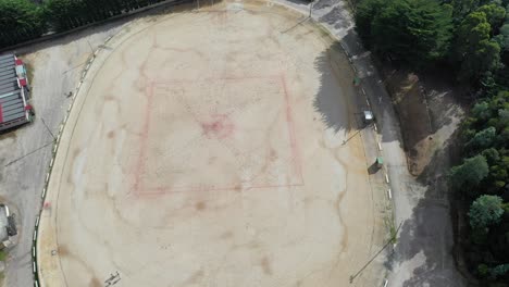wide perspective showing whole ground on sunny day - aerial drone shot queenstown oval, tasmania, australia - famous gravel oval