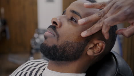 man getting a shave and haircut at a barber shop