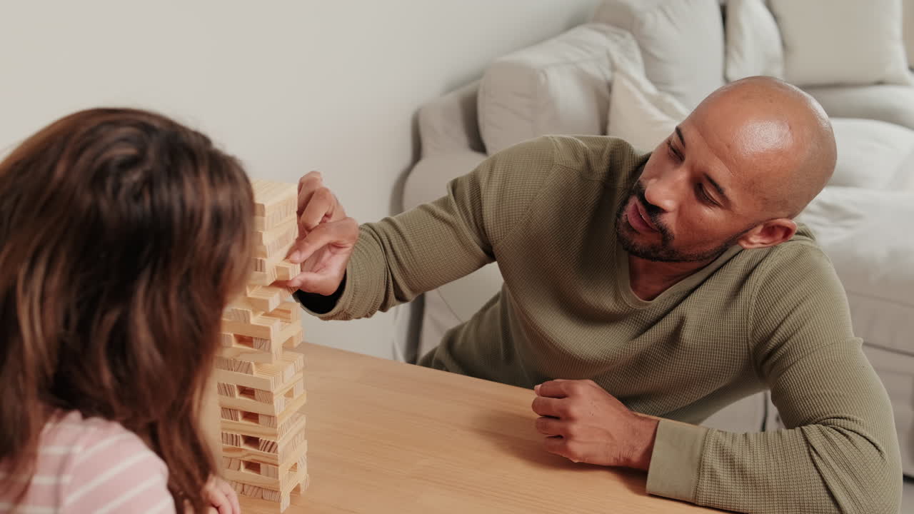 A mixed-race couple playing board games, Couple the man and the woman Jenga at