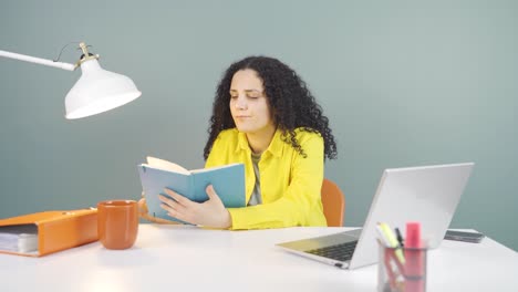 una mujer joven con un cuaderno piensa y toma notas.