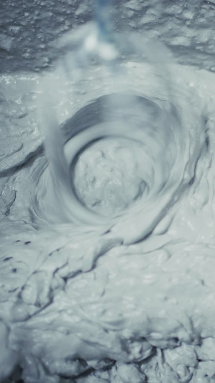 Koyu, kremamsı karışımın karıştırma işlemine yakından bakış, bir mutfak kreasyonundaki girdap hareketini ve dokusunu yakalama