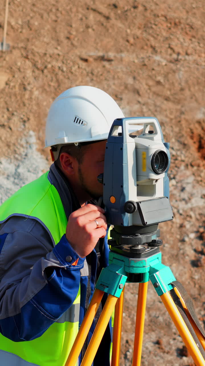 Surveyor using total station on construction site