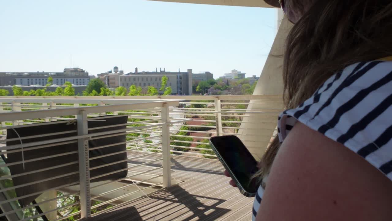 Woman Using Phone on Terminal Bridge