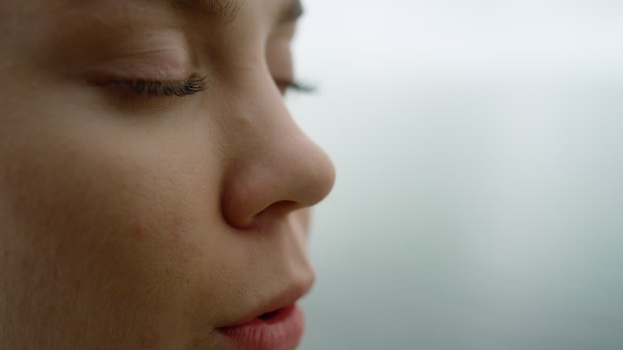 retrato de una mujer respirando profundamente haciendo ejercicio de yoga afuera con los ojos cerrados.
