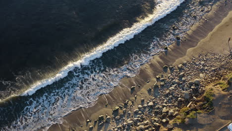 Un-Dron-Aéreo-Sobrevuela-Las-Olas-Rompiendo-En-La-Costa-Frente-A-PCH-Malibú